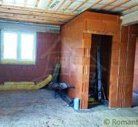 Unfinished interior of a family house with construction materials and brick walls.