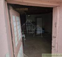 An ancient interior of a country house with old furniture and worn-out walls.