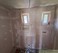 A construction room with two windows, basic structure for a cottage.