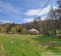 Grass in the countryside with a cottage and beautiful nature in the background, peaceful atmosphere.