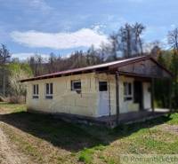 In the picture, there is a cabin surrounded by trees and nature, ideal for relaxation.