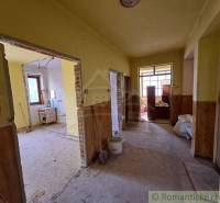 The interior of a house under renovation with open rooms, plaster, and yellow walls.
