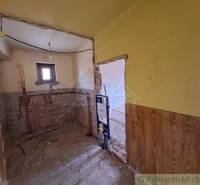 An unfinished bathroom in a family house with exposed brick walls awaits renovation.