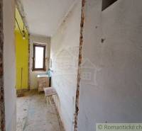 A narrow hallway with a window and a sink, preparatory work for the renovation of a family house.