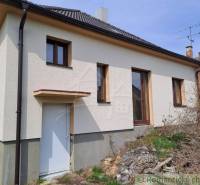 Family house with a sloped roof, plastic windows, yard with an unkempt garden.