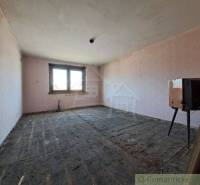 An empty room with a window, unfinished floor suitable for a family house.