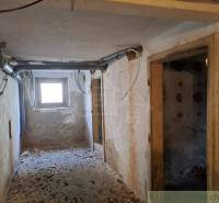 The device in the photograph looks like an abandoned family house, where damaged walls and a window are visible.