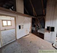 The interior of a house under construction and an empty room with an exposed roof structure.