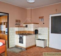 Traditional kitchen with a brick stove and wooden furniture in a family house.