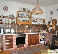 Rustic kitchen with brick decor and a tiled stove in a family house.