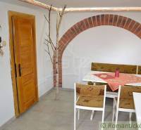 Rustic interior with a corner sofa and wooden doors, suitable for a family house.