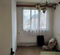 Empty room in a family house with a chandelier, window, and natural lighting.