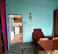 Living room in a family house, retro furniture, carpet, armchair, and entrance to the kitchen.