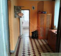 A hallway with yellow walls, tiles, a wooden wardrobe. A family house with a cozy interior.