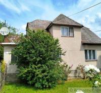 A family house in Košeca surrounded by greenery, with a simple facade and a satellite dish.