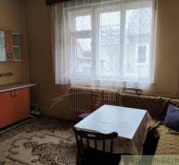A room in a family house with a wooden wardrobe and a table near the window.