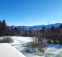 A snowy landscape with a view of mountains and trees, suitable for a family house.