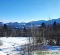 Winter landscape with mountains, trees, and a beautiful view from the **terrace** of a family house.