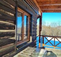 Wooden cottage with a spacious veranda, view of the snowy landscape, family house for sale.