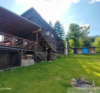 A wooden family house in nature with a terrace, lawn, and surroundings offering relaxation.