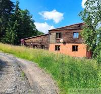 A country house with wooden elements, surrounded by nature and greenery.