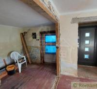Interior of a family house under renovation with an entrance door and a plastic chair.