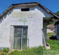 An older family house with land, renovation, natural surroundings, and sunny weather.
