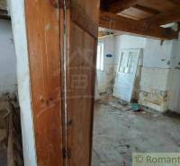 An abandoned interior in a family house needs renovation, old doors and walls are visible.