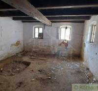 An abandoned room with wooden beams, a broken wall, located in an old family house.