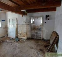 A room with leaky walls and wooden beams in a family house for renovation.