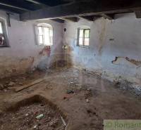 The old interior and family house need renovation, with exposed walls and wooden beams.