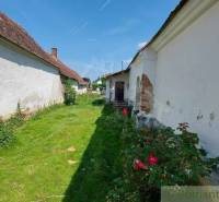 A country-style family house with a red roof, garden, romantic cottages, and flowers.