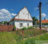 In the picture, there is a traditional family house with a front garden and a gate.