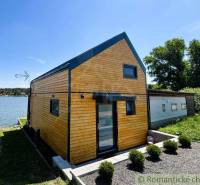 A cottage by the lake in Jakubov with wooden cladding and modern design in a natural setting.