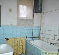 Bathroom of a family house with a bathtub, sink, blue and white tiles.