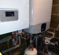 The image shows a boiler room with modern boilers and piping in a family house.