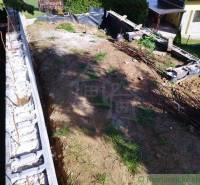 Excavation and foundations for the construction of a retaining wall at a family house.