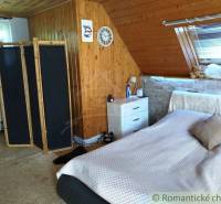 Attic room, wooden paneling, screens, bed, window with blinds, interior of a family house.