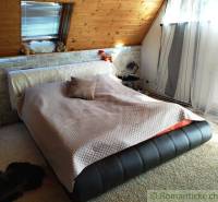 Loft bed with blanket, pillows, and curtains, suitable for a family house.