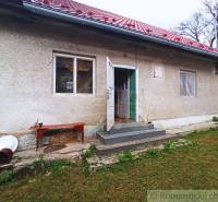 A family house with stairs, a red roof, and a lawn, offering possibilities for weekenders.