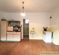 A kitchen in a family house, retro furniture, tiles, stove, lamp, simple furnishings.
