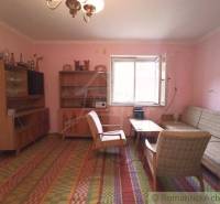 Living room of a family house with retro furniture, an open window, and a carpet.