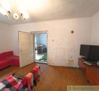 Living room of a family house with a sofa, television, and parquet flooring.