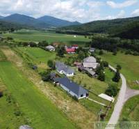 A rural landscape with cottages, forests, and mountains on the horizon, a peaceful atmosphere ideal for relaxation.