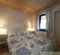A cozy room in a wooden cabin, a bed with lamps, a pleasant cabin atmosphere.