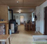 A wooden interior with a fireplace, dining table, and rustic elements creates a cozy atmosphere in the cabin.