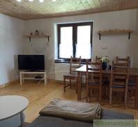 Rustic cottage with wooden ceiling, furniture, and television, providing a cozy space for relaxation.