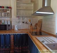 A visible kitchen in a cottage with traditional elements and appliances, including a microwave.