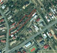 An aerial photograph shows an urban area with houses, surrounded by roads and a playground.