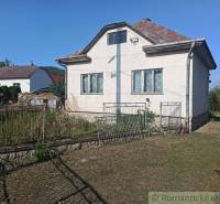 Family house with a white facade, sloped roof, garden, metal fence, peaceful location.